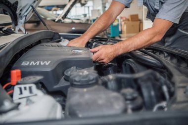Bmw otomobil reklamları, Moskova, 1.11.2018: Araba tamiri ve temizlik konsepti - araba motoru yakın çekim, kaputun altındaki parçaları silme