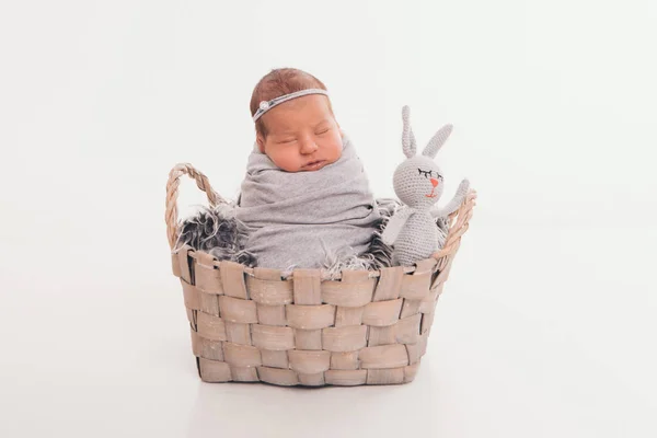 Een klein kind in een mand met speelgoed wit konijn. concept van kindertijd, gezondheidszorg, Ivf, gift, dier. geïsoleerd op witte backgrpund — Stockfoto