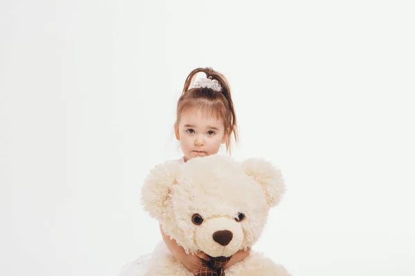 A small child with toy Taddy bear. Girl playing on white background. Concept of gift, childhood — Stock Photo, Image