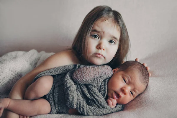 The concept of a healthy lifestyle, the protection of children, shopping - a child with a newborn baby playing together. Happy kids: girls on white background — Stock Photo, Image