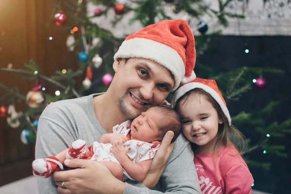Семья в рождественских шляпах. Концепция празднования Нового года, костюмы Санта-Клауса и снегурочки, подарки — стоковое фото