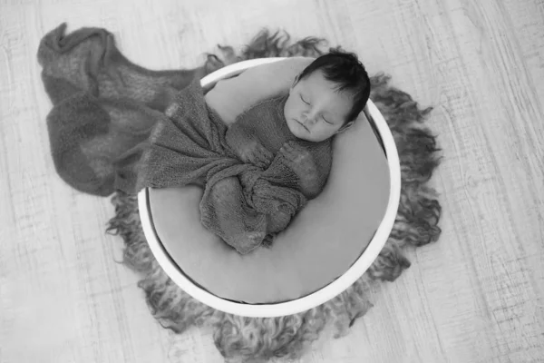 Bebê recém-nascido envolto em um cobertor dormindo em uma cesta. conceito de infância, saúde, FIV. Foto em preto e branco — Fotografia de Stock