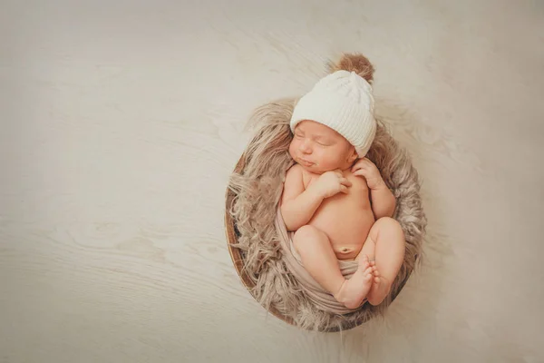 Um bebê recém-nascido envolto em um cobertor com um chapéu quente na cabeça. o conceito de infância, saúde, FIV . — Fotografia de Stock