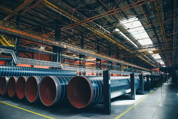 Concepto de la industria pesada, maquinaria de construcción tubos largos de metal dentro de una habitación grande. Materiales de construcción en el hangar — Foto de Stock