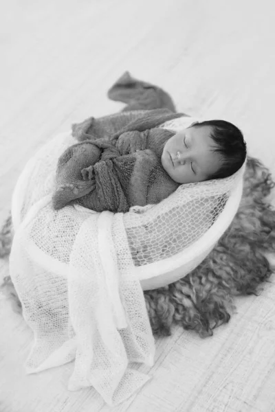 Pasgeboren baby verpakt in een deken slapen in een mand. concept van kindertijd, gezondheidszorg, IVF. Zwart-wit foto — Stockfoto
