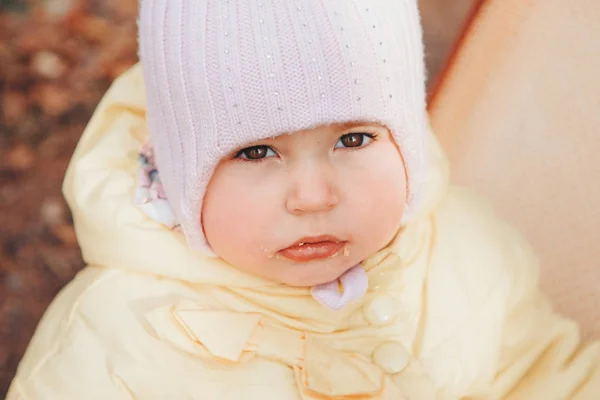 Une petite fille avec un chapeau chaud sur la tête sourit. le concept d'enfance, santé, FIV, temps froid — Photo