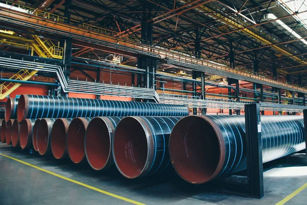 Concepto de la industria pesada, maquinaria de construcción tubos largos de metal dentro de una habitación grande. Materiales de construcción en el hangar — Foto de Stock