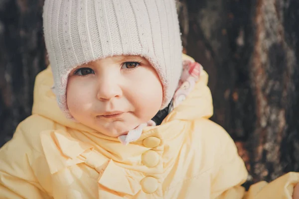 Une petite fille avec un chapeau chaud sur la tête sourit. le concept d'enfance, santé, FIV, temps froid — Photo