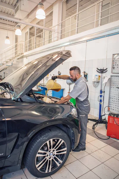 広告BMW車,モスクワ, 1.11.2018:車の修理とクリーニングの概念-車のエンジンのクローズアップ,フードの下に部品を拭く — ストック写真
