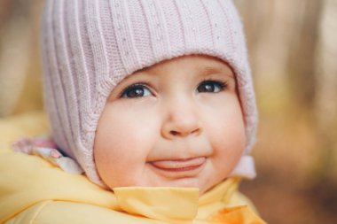 Kafasında sıcak bir şapka olan küçük bir kız gülümsedi. çocukluk konsepti, sağlık, lvf, soğuk zaman