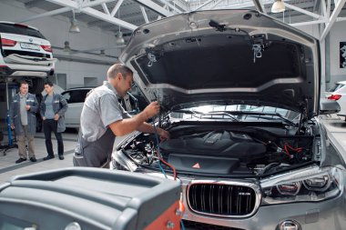 Bmw otomobil reklamları, Moskova, 1.11.2018: Araba tamiri ve temizlik konsepti - araba motoru yakın çekim, kaputun altındaki parçaları silme