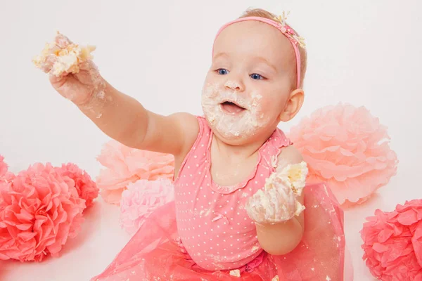 白い背景に手でケーキを食べる少女。子供は食べ物に覆われている。甘さを台無しにした。誕生日、休日、料理の概念 — ストック写真