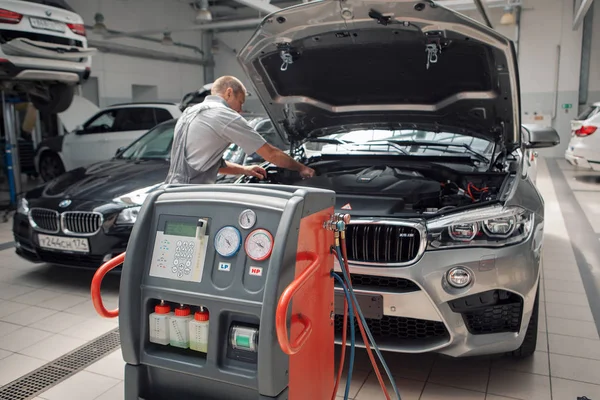 広告BMW車,モスクワ, 1.11.2018:車の修理とクリーニングの概念-車のエンジンのクローズアップ,フードの下に部品を拭く — ストック写真