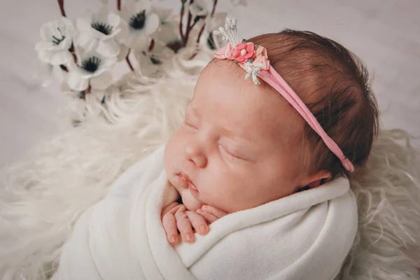 Портрет спящего новорожденного в повязке с цветами. Концепция здоровья: ЭКО, детские аксессуары — стоковое фото