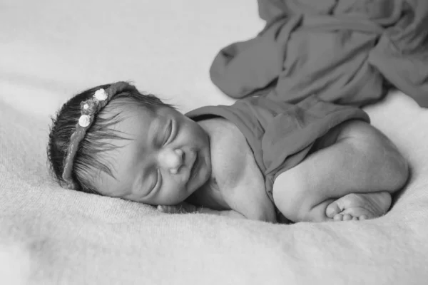 Porträtt av ett sovande nyfött barn i ett pannband med blomma. Hälsokoncept: Ivf, babytillbehör — Stockfoto