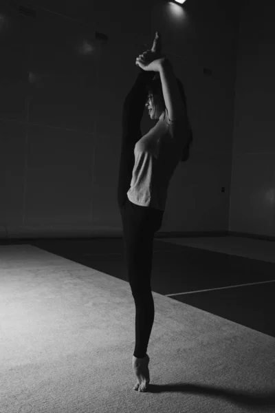 Kvinnan satte sig på tråden. Lektioner på gymmet. Flickan är engagerad i gymnastik. idrottsövningar och stretching: friidrott — Stockfoto