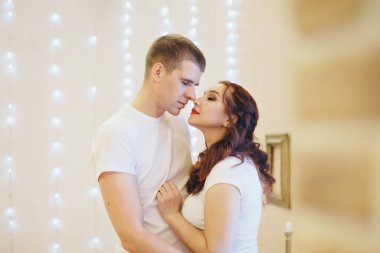 Birbirlerine aşık çiftler arka planda sarılıyorlar. Bir erkek ve bir kadın birbirlerinin gözlerinin içine bakar. Sevgililer Günü. 14 Şubat