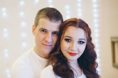 Birbirlerine aşık çiftler arka planda sarılıyorlar. Bir erkek ve bir kadın birbirlerinin gözlerinin içine bakar. Sevgililer Günü. 14 Şubat