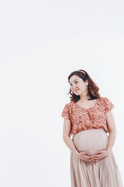 Pregnant woman stroking her belly on white background. Copy space. The concept of healthy digestion, lifestyle, IVF — Stock Photo, Image