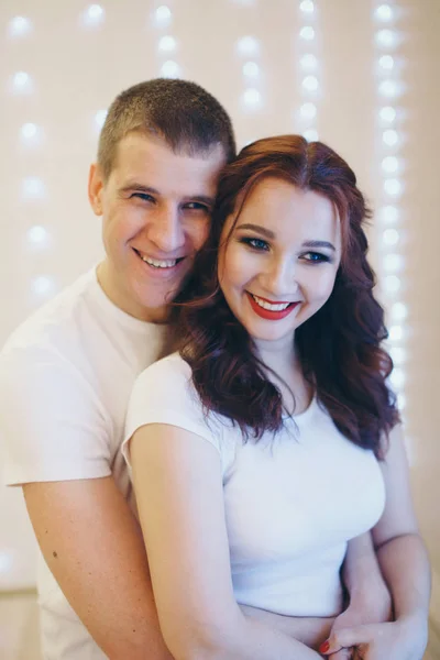 Casal apaixonado abraçando em um fundo leve. Um homem e uma mulher olham nos olhos um do outro. Dia dos Namorados. 14 de Fevereiro — Fotografia de Stock