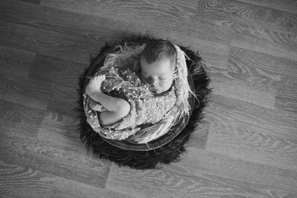 Bebé recién nacido envuelto en una manta durmiendo en una canasta. concepto de infancia, salud, FIV. Foto en blanco y negro — Foto de Stock