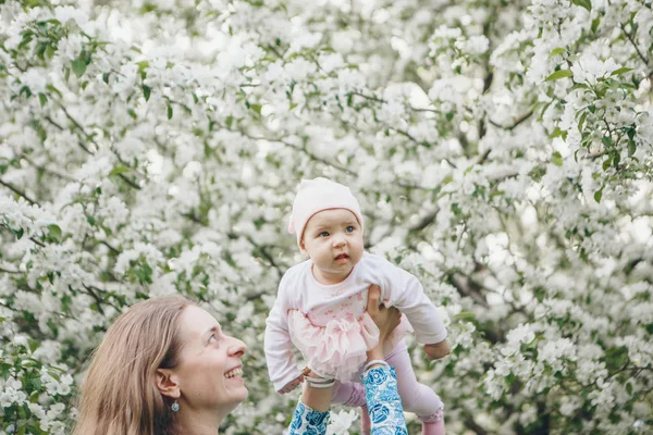 beautiful woman holding children. March 8: women among flowers. the concept of congratulations, women\'s holidays, natural make up