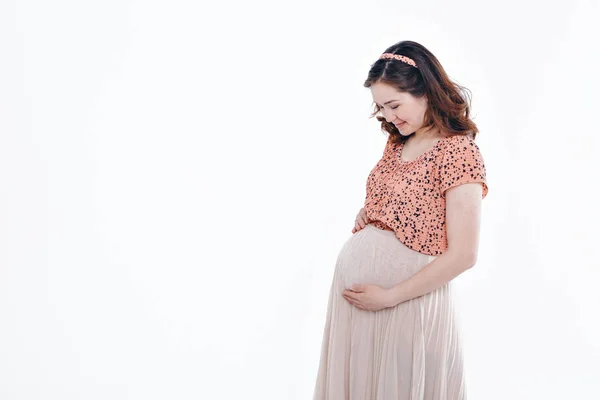 Pregnant woman stroking her belly on white background. Copy space. The concept of healthy digestion, lifestyle, IVF — Stock Photo, Image