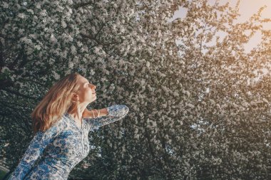 Çiçek tutan güzel bir kız. 8 Mart: Çiçeklerin arasındaki kadın. Tebrikler kavramı, kadın tatili, doğal makyaj.