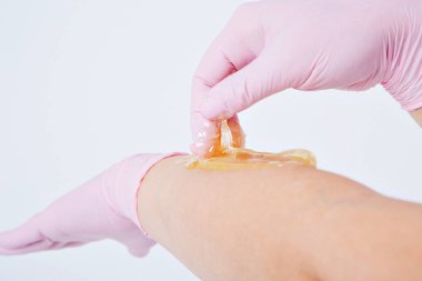 Eller lastik eldivenlerin içinde, yakın plan. Doktor ağda yaptırır, tatlım. Sıhhiye tüy dökülmesine hazırlanıyor. Tıp, sağlık, güzellik endüstrisi, saç kesimi, doğal malzeme kavramı. Boşluğu kopyala