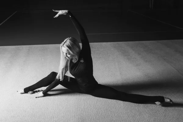 La mujer se sentó en la cuerda. clases en el gimnasio. la muchacha se ocupa de la gimnasia recreativa. ejercicios deportivos y estiramientos: atletismo — Foto de Stock