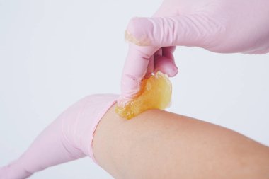 Eller lastik eldivenlerin içinde, yakın plan. Doktor ağda yaptırır, tatlım. Sıhhiye tüy dökülmesine hazırlanıyor. Tıp, sağlık, güzellik endüstrisi, saç kesimi, doğal malzeme kavramı. Boşluğu kopyala