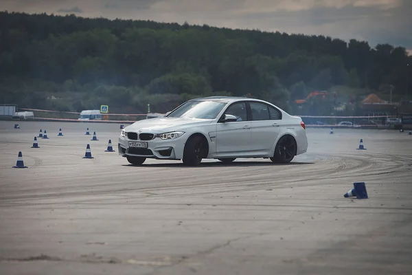 Publicidade BMW, Moscou, 1.11.2018: demonstração do modelo do carro, carros na pista de teste, poeira de baixo das rodas, faixas na estrada, corrida, treinamento de condução em uma escola de condução — Fotografia de Stock