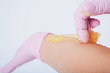 Eller lastik eldivenlerin içinde, yakın plan. Doktor ağda yaptırır, tatlım. Sıhhiye tüy dökülmesine hazırlanıyor. Tıp, sağlık, güzellik endüstrisi, saç kesimi, doğal malzeme kavramı. Boşluğu kopyala