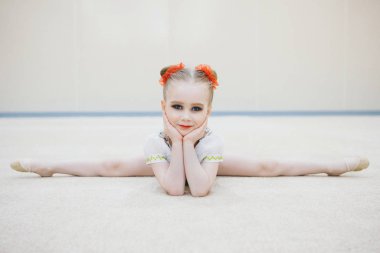 Kız sicimin üzerine oturdu. fitness kulübündeki dersler. Kız eğlence amaçlı jimnastik yapıyor. Spor egzersizleri ve esneme: atletizm