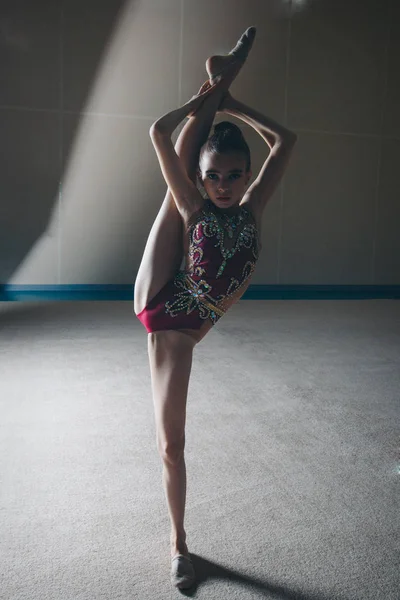 La chica se sentó en la cuerda. clases en el gimnasio. la muchacha se ocupa de la gimnasia recreativa. ejercicios deportivos y estiramientos: atletismo — Foto de Stock