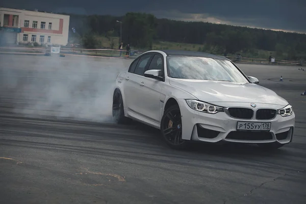 Publicidad BMW, Moscú, 1.11.2018: demostración del modelo de coche, coches en la pista de pruebas, polvo de debajo de las ruedas, pistas en la carretera, carrera, entrenamiento de conducción en una escuela de conducción — Foto de Stock