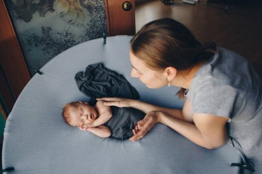 Yeni doğmuş bebek ebeveynlerinin ellerinde yatıyor. Rahimdeki bebeğin taklidi. Güzel küçük kız sırt üstü uyuyor. Aşkın dışavurumu. Sağlık konsepti, ebeveynlik, çocuk günü, tıp, lvf