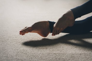 Jimnastikçinin bacakları kapalı. Bale parmaklarının ucunda duruyor. Spor egzersizleri ve esneme: atletizm