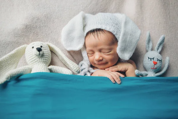 Noworodek w kapeluszu z latami sypiający z lalką. Naśladowanie dziecka w łonie matki. Portret noworodka. z królikiem. Koncepcja opieki zdrowotnej, rodzicielstwo, Dzień Dziecka, medycyna, Ivf — Zdjęcie stockowe