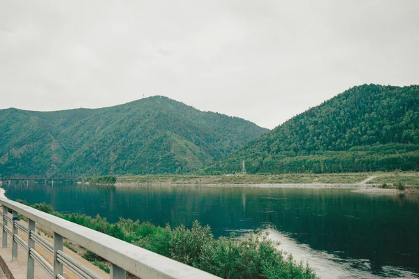 the concept of boating, recreation, travel - splashes of blue water in the river, mountains, sky, stone shore. Copy space