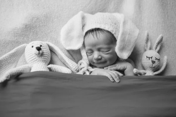 Bebé recién nacido en sombrero con años durmiendo con la muñeca. Imitación de un bebé en el útero. Retrato del recién nacido. con conejo. Concepto de cuidado de la salud, paternidad, Día del Niño, medicina, FIV —  Fotos de Stock