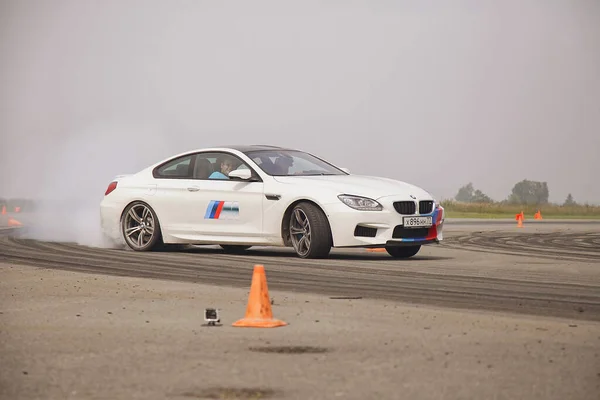 Publicidade BMW, Moscou, 1.11.2018: demonstração do modelo do carro, carros na pista de teste, poeira de baixo das rodas, faixas na estrada, corrida, treinamento de condução em uma escola de condução — Fotografia de Stock
