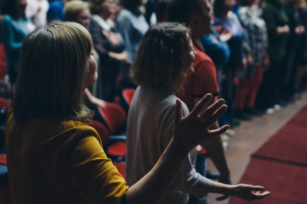 hands raised in the crowd. A group of people stretches out their hands. Bright lighting. personal growth training. Warm-up for the audience - all raised their hands up and reach up