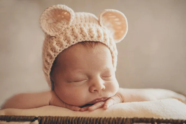Kulakları olan örgü şapkalı yeni doğmuş bir bebek. Rahimdeki bir bebeğin taklidi gibi. Yeni doğmuş bir bebeğin portresi. Sağlık, ebeveynlik, çocuk günü, tıp, tüp bebek konsepti