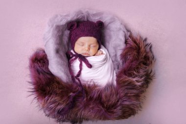 Kulakları olan örgü şapkalı yeni doğmuş bir bebek. Rahimdeki bir bebeğin taklidi gibi. Yeni doğmuş bir bebeğin portresi. Sağlık, ebeveynlik, çocuk günü, tıp, tüp bebek, moda