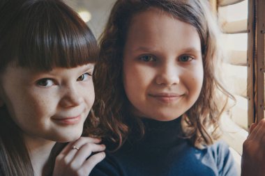 Pencerenin yanındaki kız. Çocuk dışarı bakıyor. Yaşam tarzı kavramı, tatiller