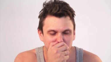 Beyaz arka planda bir adamın portresi. Evde kendini izole eden hasta. Hasta şiddetle öksürüyor. Karantina, kendini izole etme, koronavirüsten koruma, virüs, hastalık korkusu, tedavi, ilaç, akciğer hasarı, pnömo