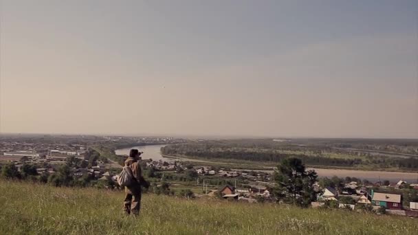 Чоловік Рюкзаком Плечах Йде Через Луг Турист Подорожує Сільські Будинки — стокове відео