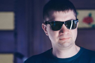 Siyah gözlüklü yakışıklı bir adam. Acımasız bir adamın portresi. reklam gözlüğü