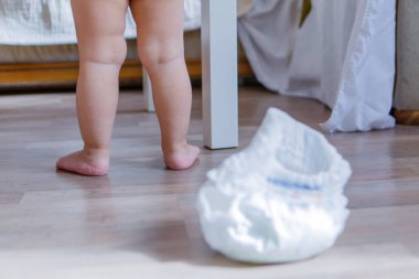 Bebek ve bebek bezi. Bebek tuvalet üzerinde yürümeyi öğrendi. Kullanılmış malzeme. Sağlıklı sindirim sistemi kavramı, ebeveynlere yardım etmek, tuvalet eğitimi